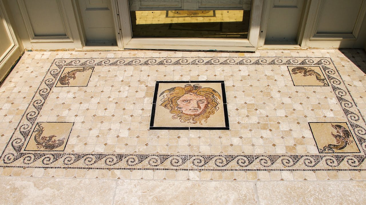 Antique style outdoor travertine mosaic is used to create a decorative entryway or a pathway