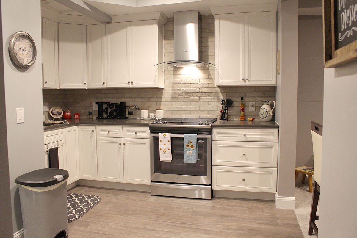 Small kitchen with white cabinets and brick backsplash