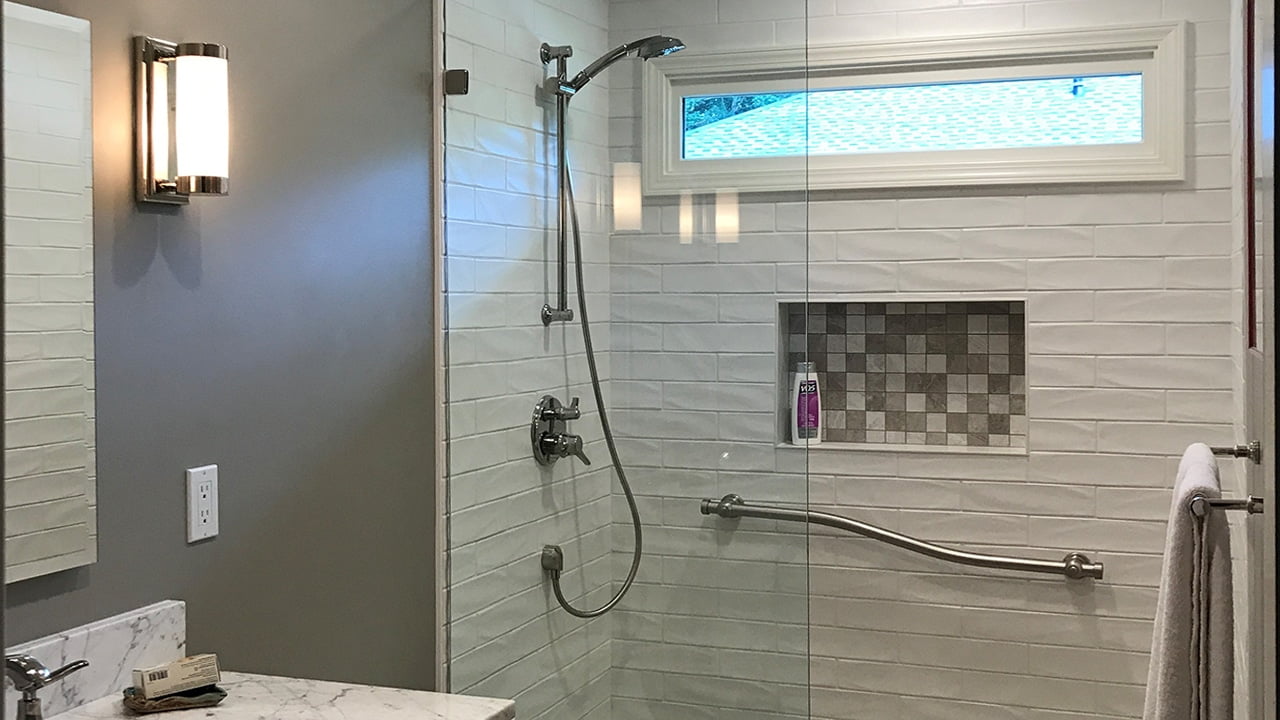 Marble grey and taupe mosaic used to decor the shampoo niche of a white subway tile shower